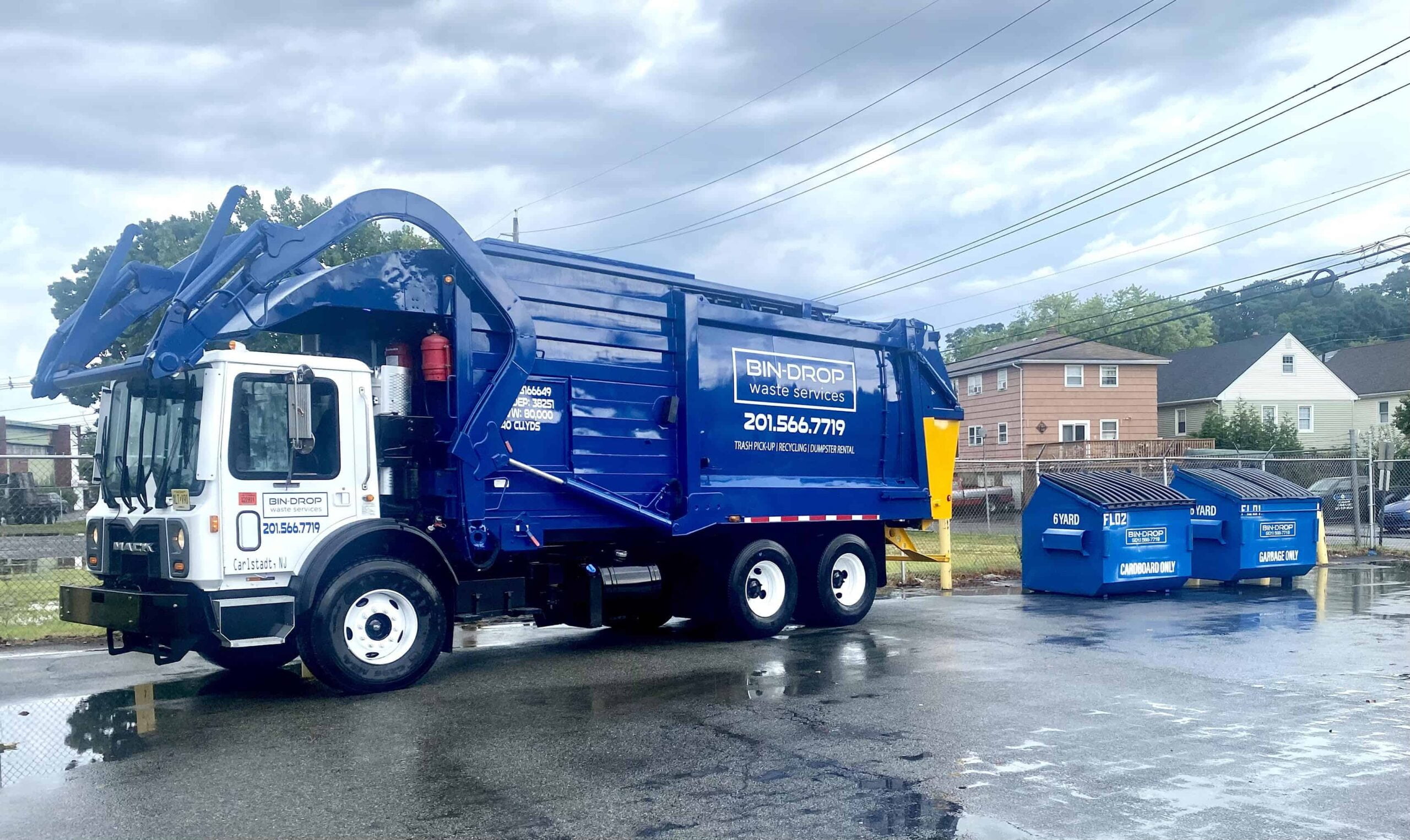 Bin-Drop commercial rear load truck servicing apartment alley pickup